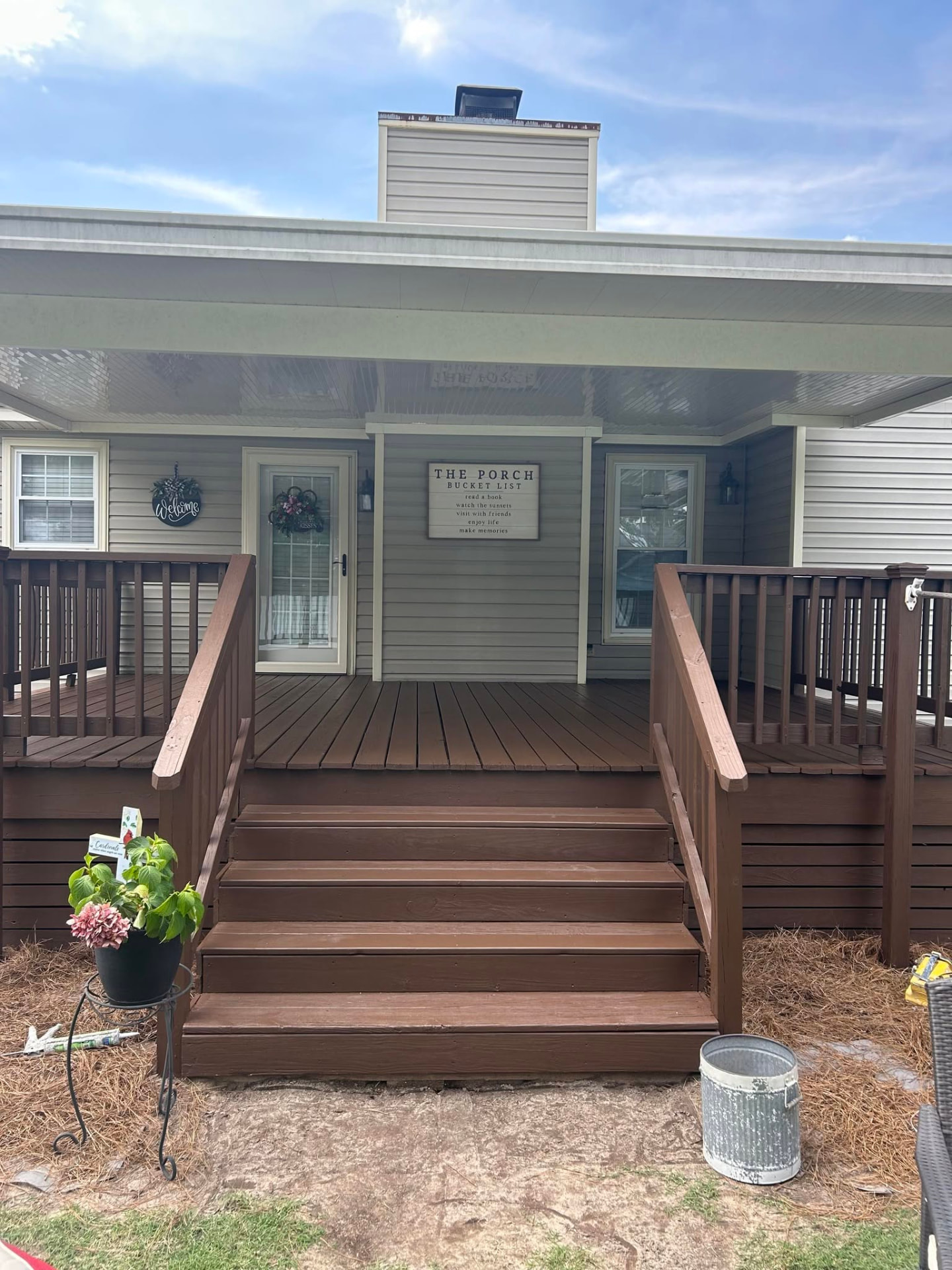 Same deck and porch after a rich brown stain and fresh paint